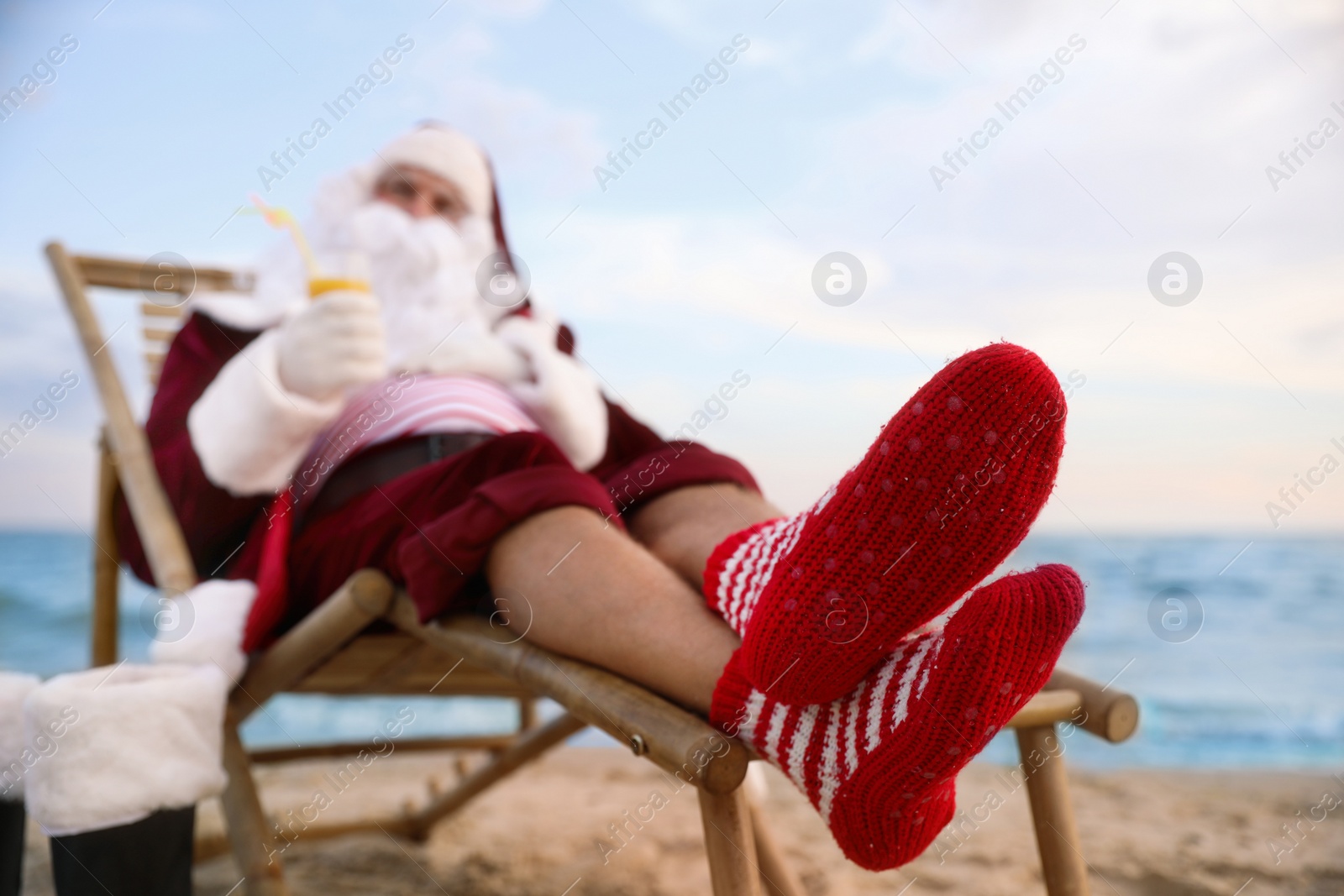 Photo of Santa Claus relaxing on beach. Christmas vacation