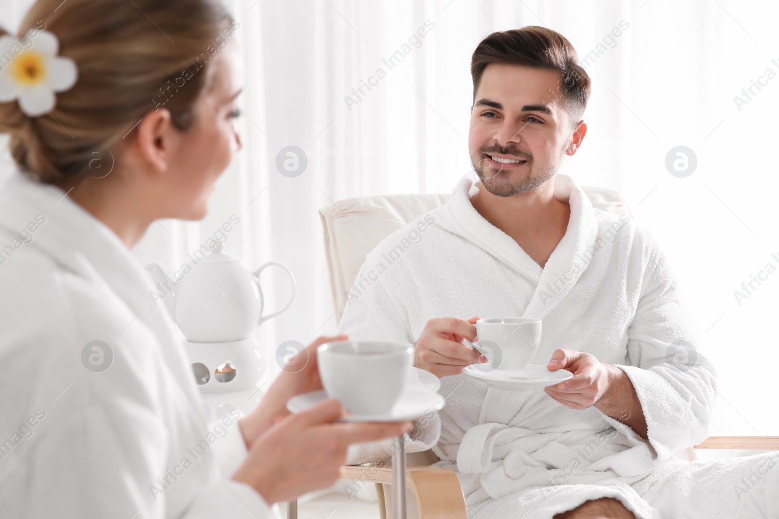 Photo of Romantic young couple with tea in spa salon