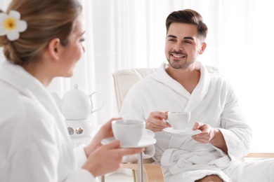 Photo of Romantic young couple with tea in spa salon