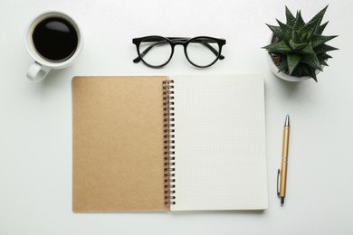 Flat lay composition with open notebook on white table. Space for text