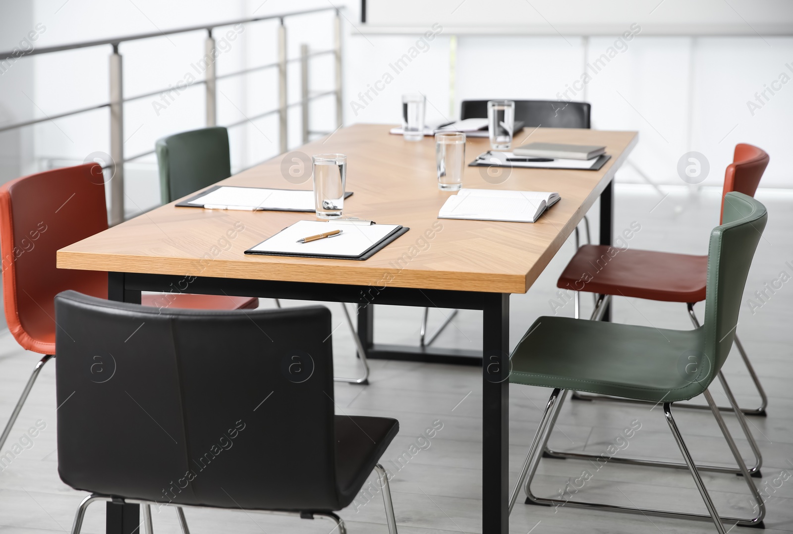 Photo of Clipboards and glasses of water on wooden table in modern office