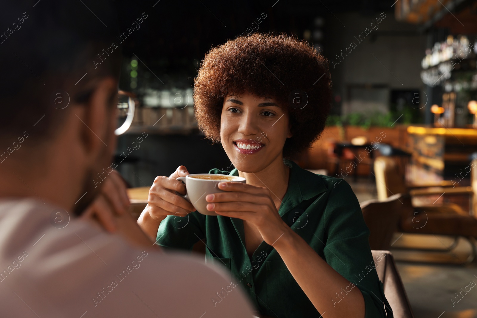 Photo of International dating. Lovely couple spending time together in cafe