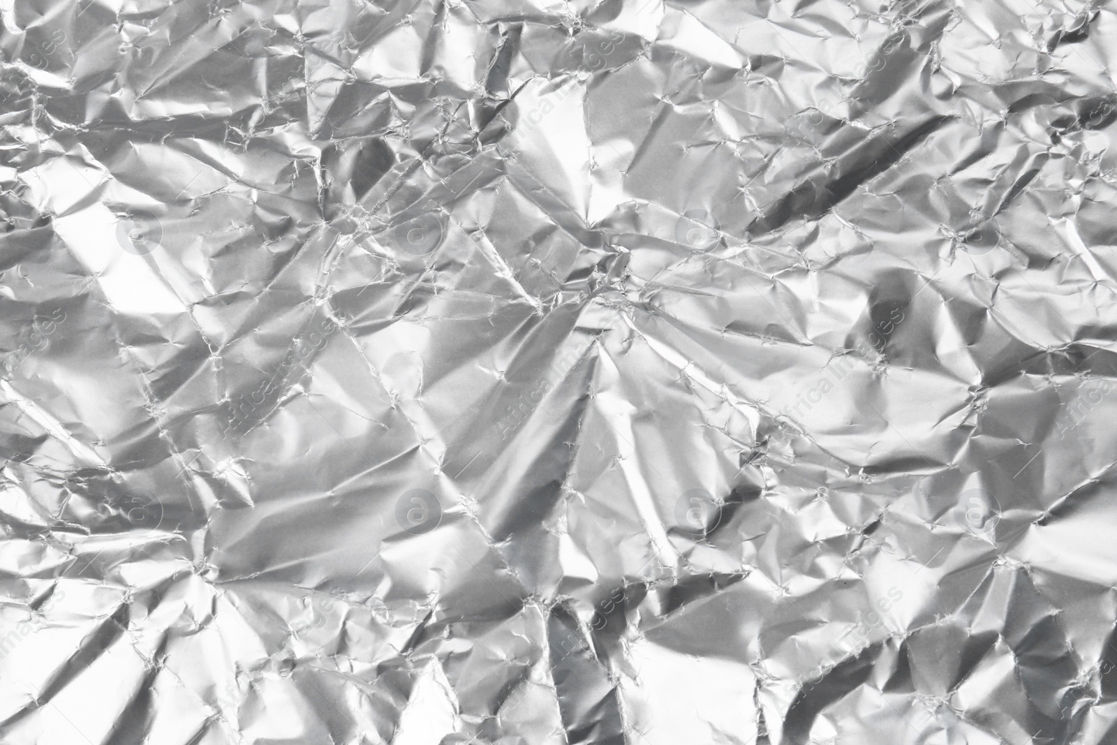 Photo of Crumpled silver foil as background, closeup view