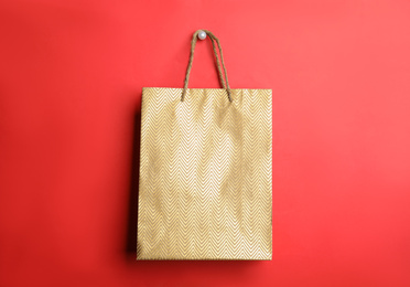 Photo of Gold shopping paper bag on red background