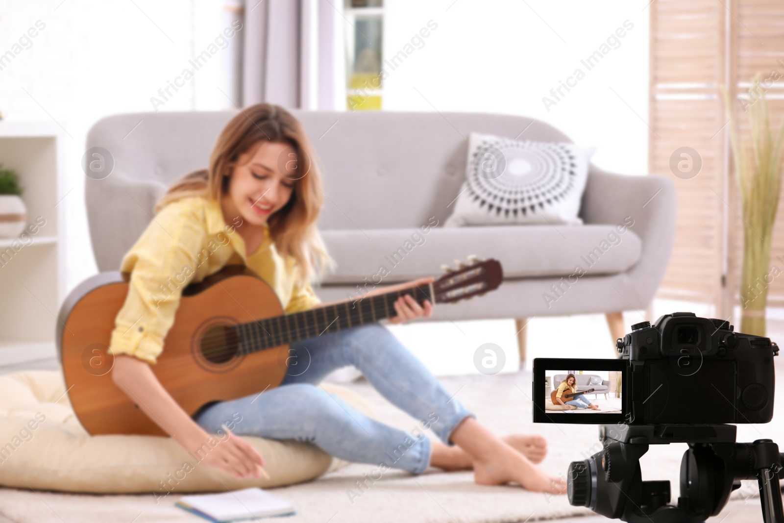 Image of Music teacher recording guitar lesson at home