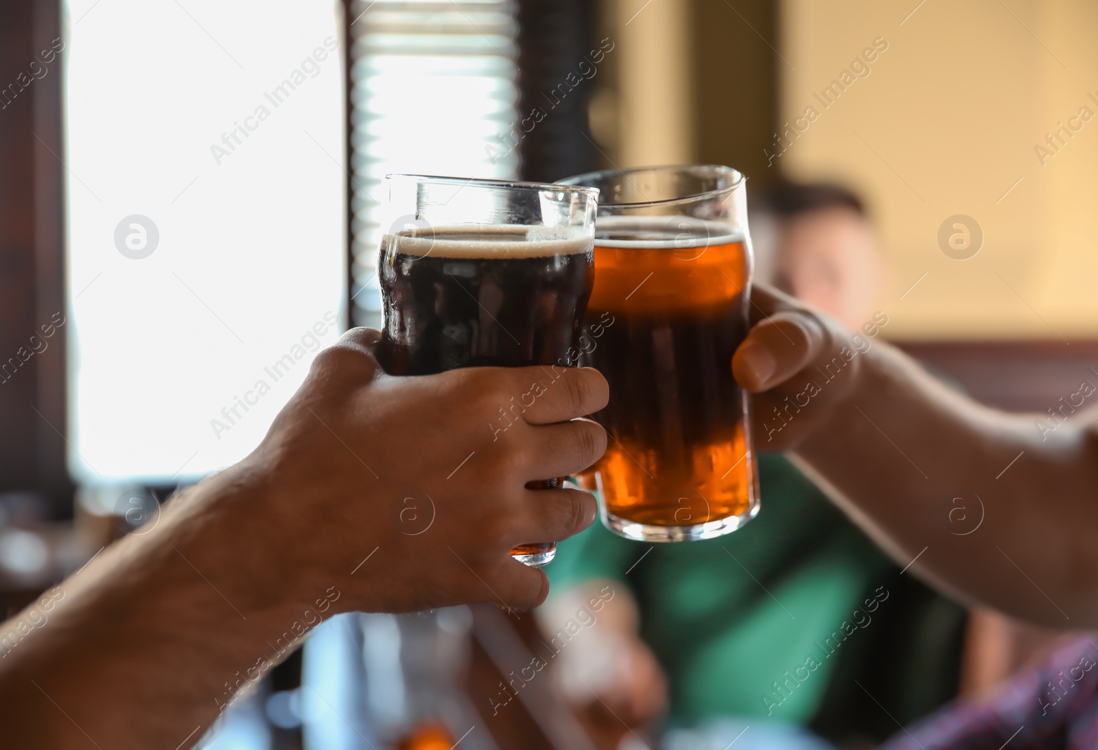 Photo of Friends clinking glasses with beer in pub