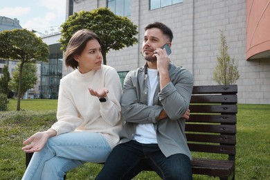 Photo of Man ignoring his girlfriend and talking on phone. Relationship problems