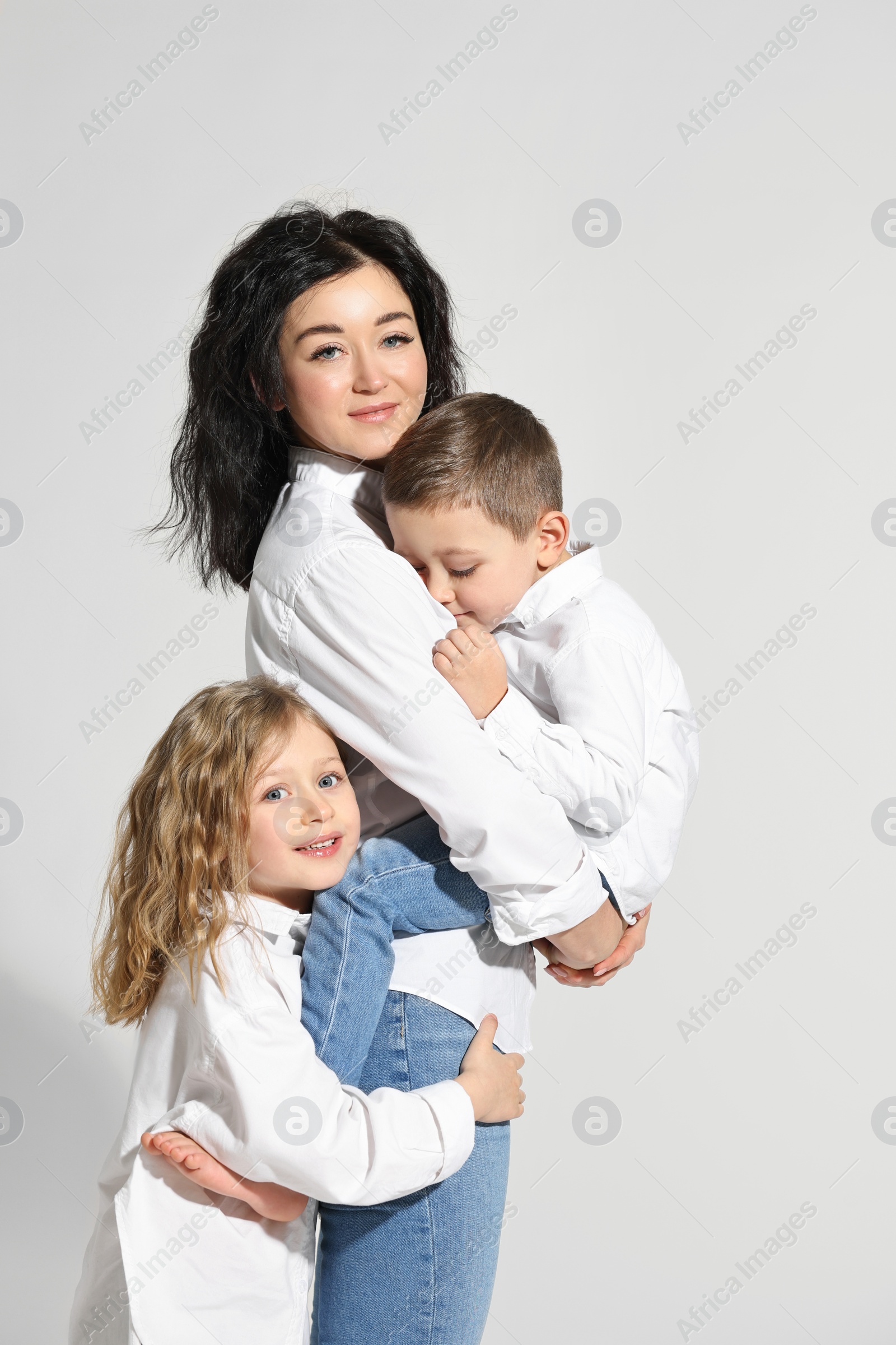 Photo of Little children with their mother on white background