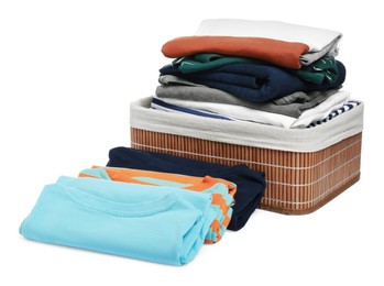 Photo of Wicker laundry basket and clean clothes on white background