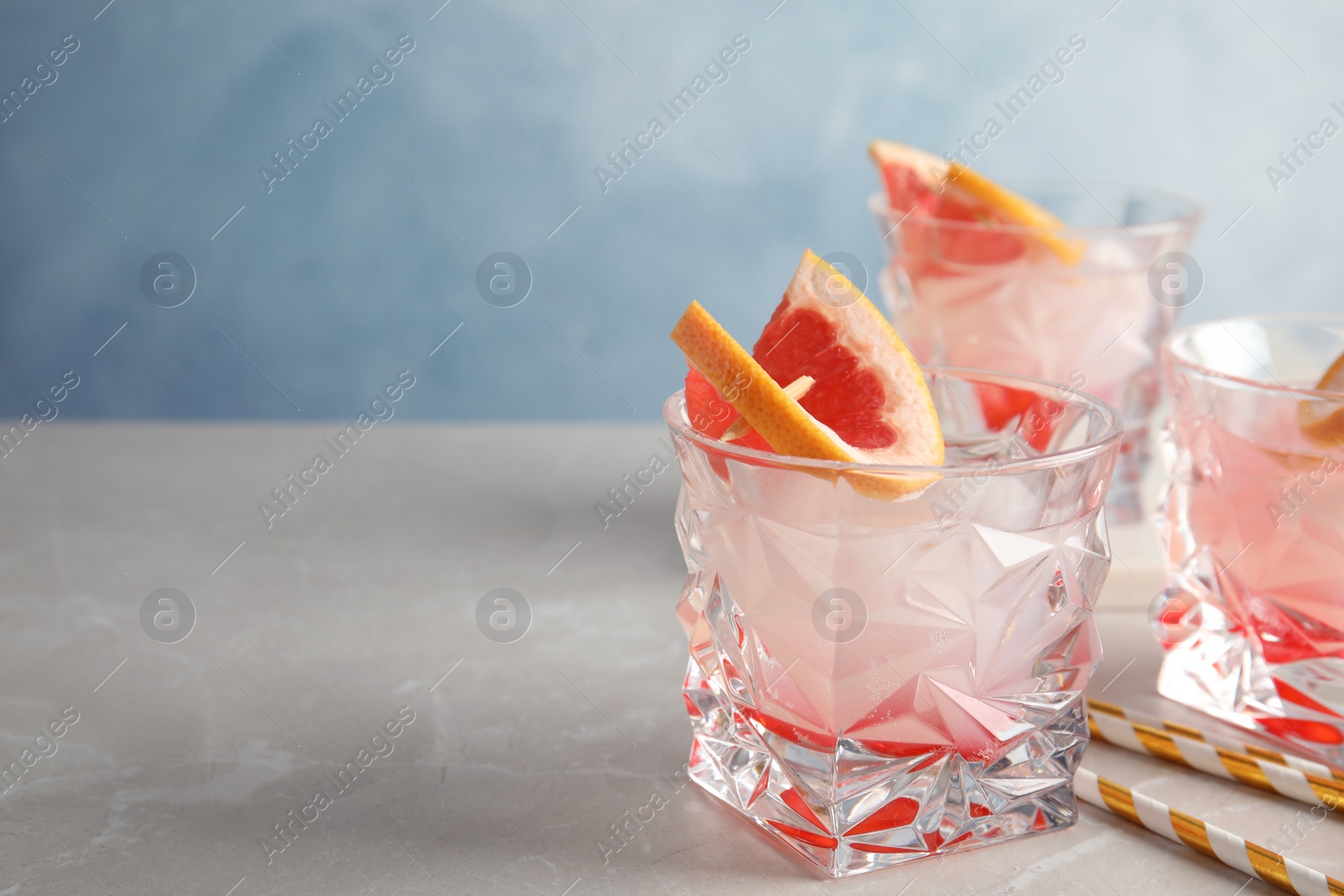 Photo of Glasses of grapefruit cocktails on table. Space for text