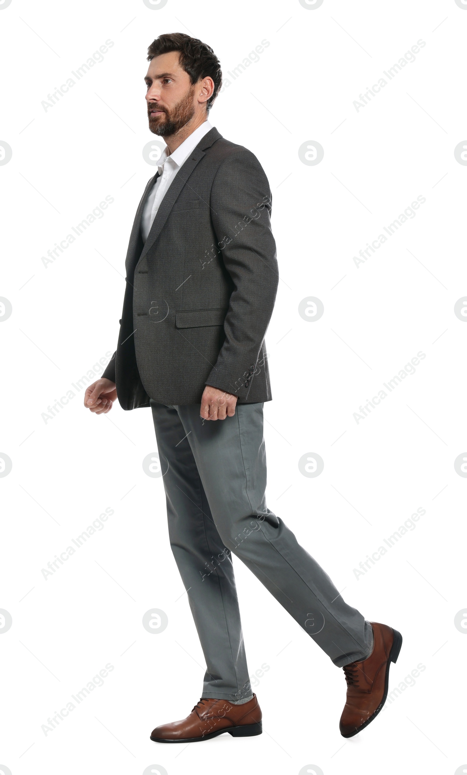 Photo of Handsome man in suit walking on white background