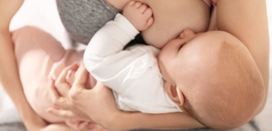 Image of Young woman breast feeding her little baby, closeup. Banner design