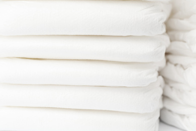 Stack of baby diapers as background, closeup