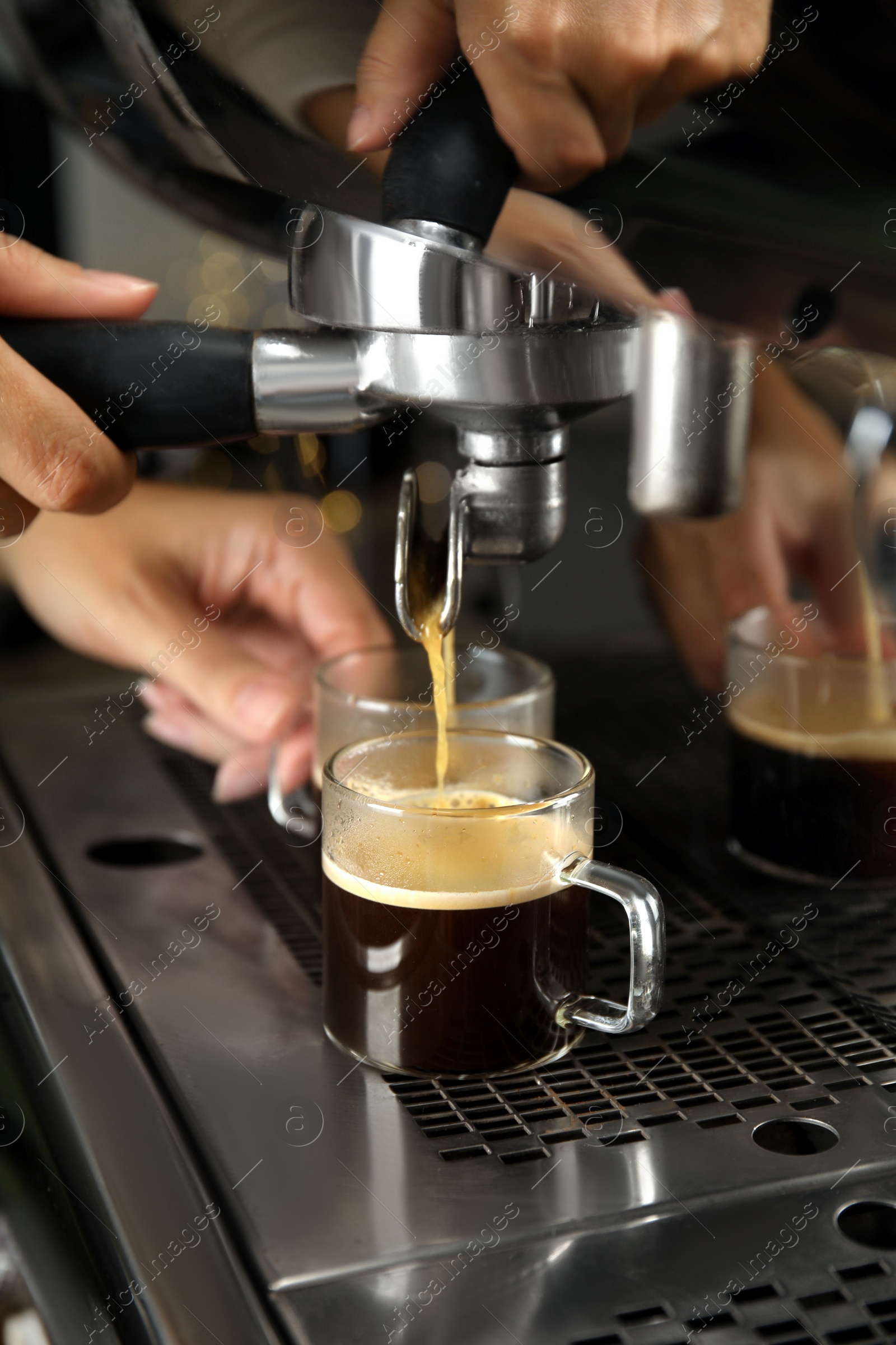 Photo of Barista making espresso using professional coffee machine, closeup