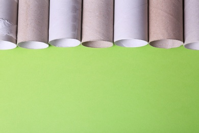 Photo of Empty toilet paper rolls and space for text on color background