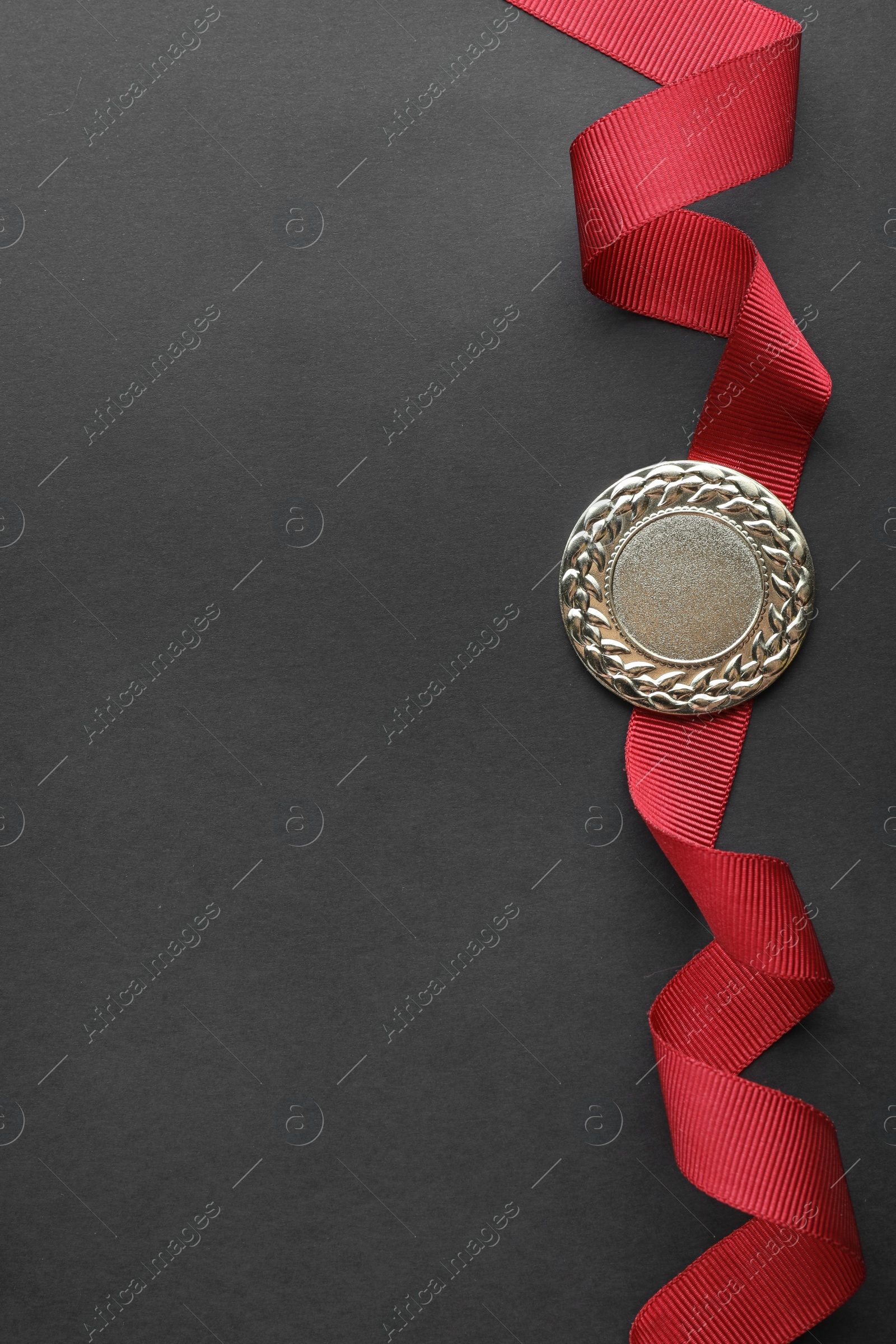 Photo of Gold medal on black background, top view with space for text. Symbol of victory