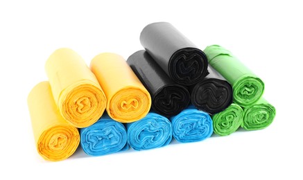 Photo of Rolls of colorful garbage bags isolated on white