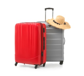 Photo of Packed suitcases with hat on white background