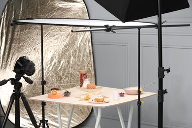 Photo of Professional equipment and composition with delicious desserts on table in studio. Food photography