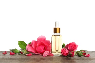 Photo of Bottle of rose essential oil and flowers on table, white background