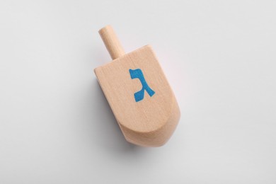 Photo of Wooden dreidel on white background, top view. Traditional Hanukkah game