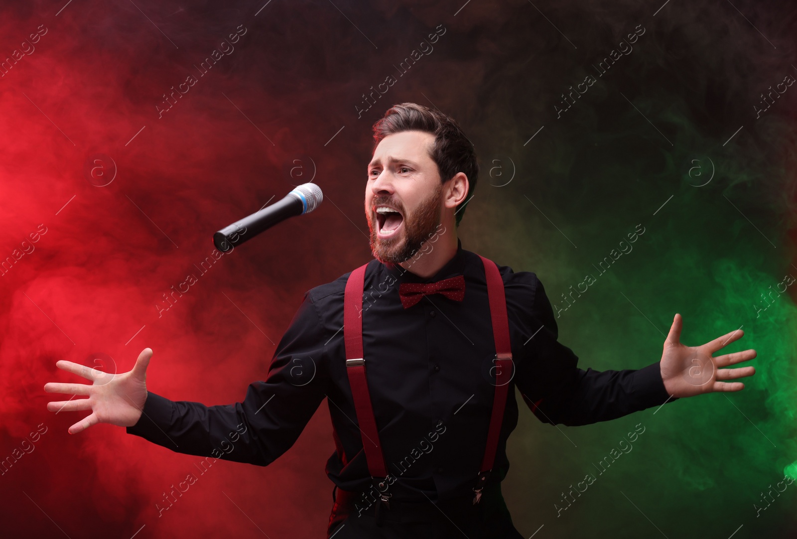 Photo of Emotional singer performing in red and green lights