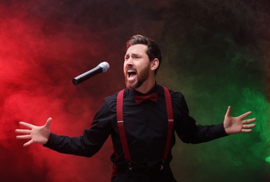 Photo of Emotional singer performing in red and green lights