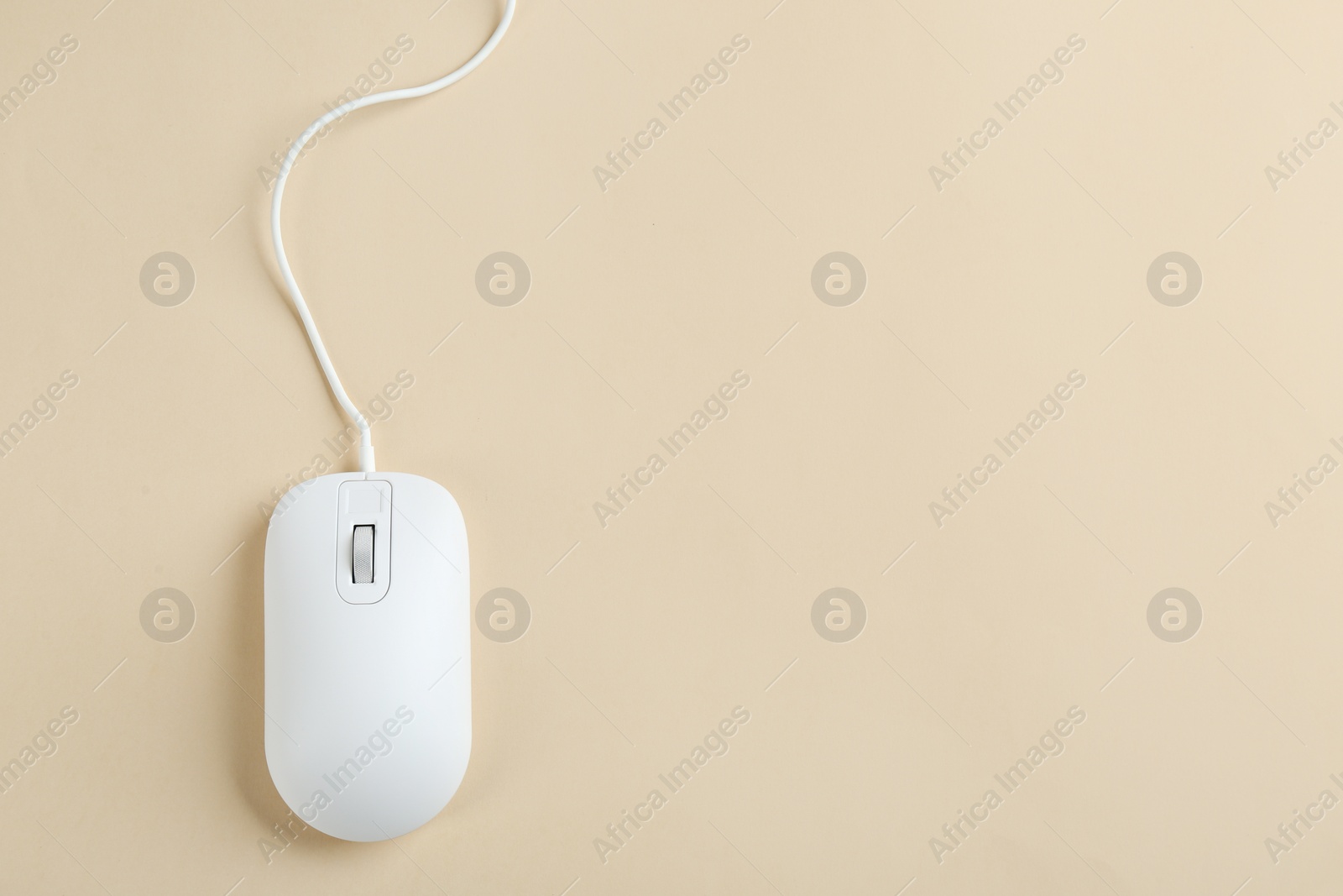 Photo of Modern wired optical mouse on beige background, top view. Space for text