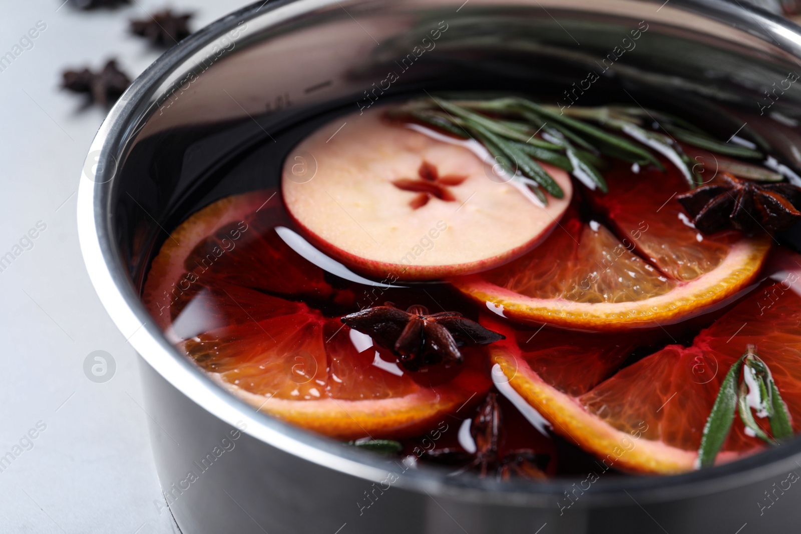 Photo of Tasty mulled wine with spices in saucepan, closeup