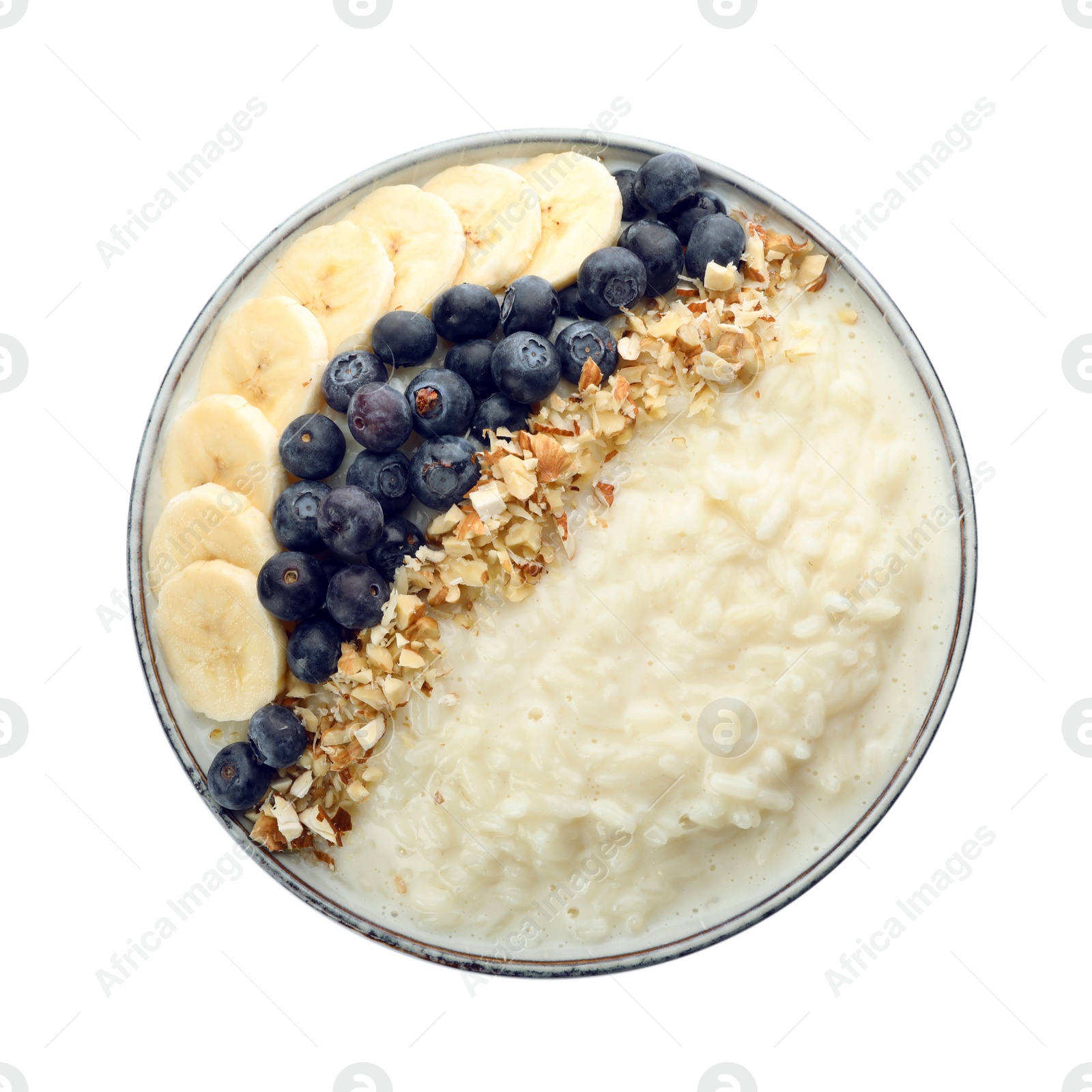 Photo of Delicious rice pudding with banana, blueberries and almond isolated on white, top view