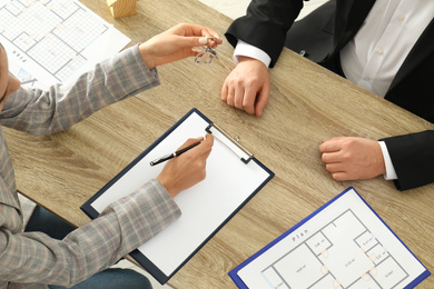 Photo of Real estate agent working with client at table, above view