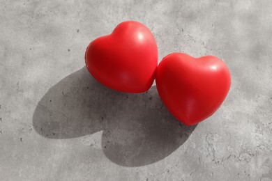 Photo of Two decorative hearts on gray textured table, above view