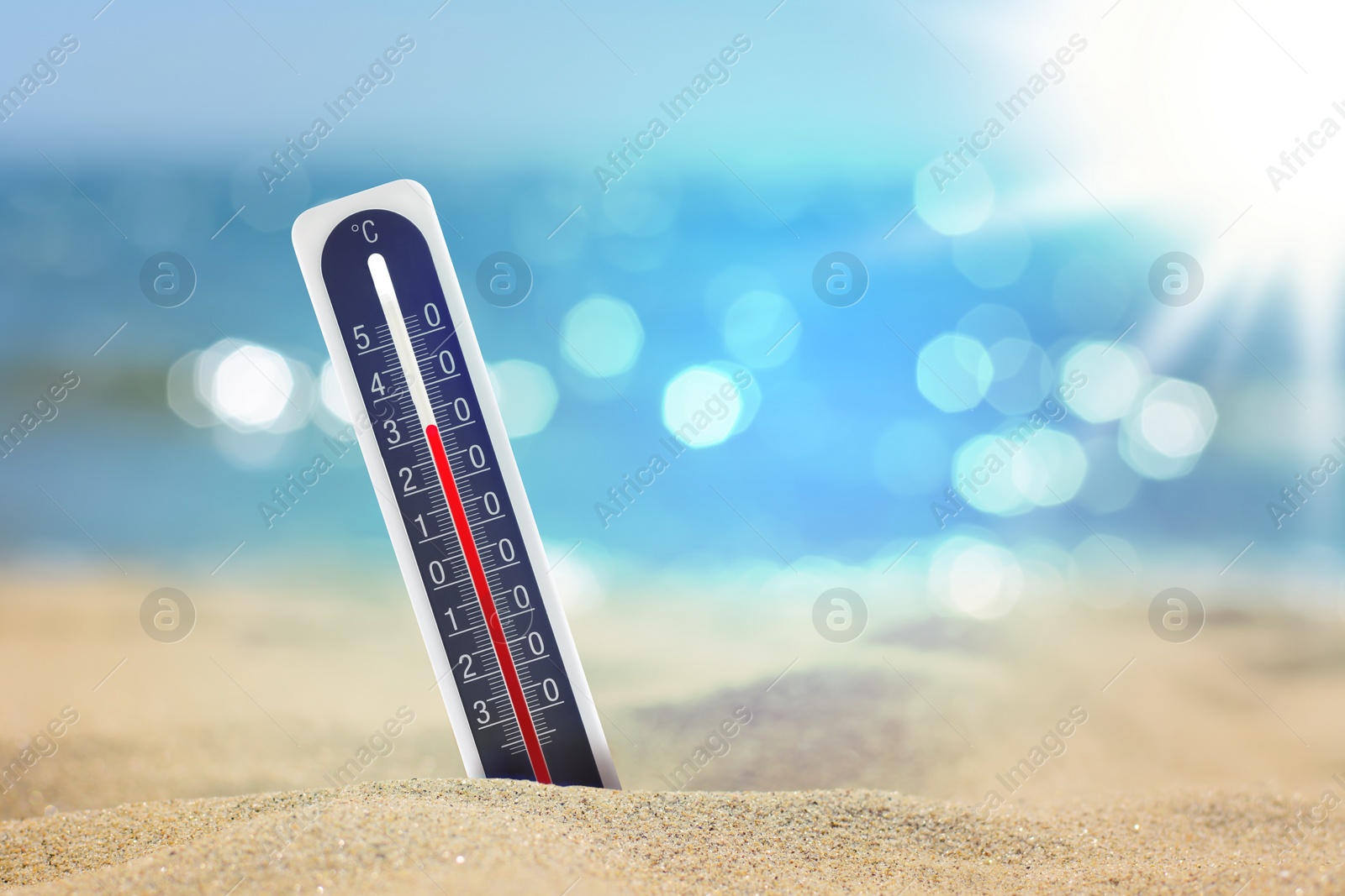 Image of Thermometer on beach showing high temperature during summer day