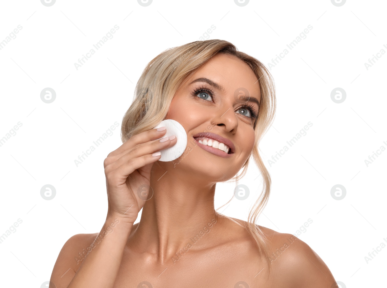 Photo of Smiling woman removing makeup with cotton pad on white background