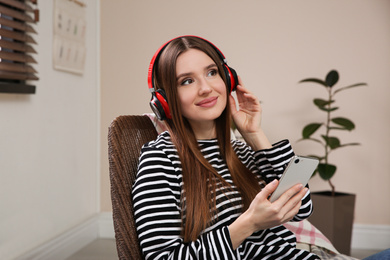 Photo of Woman listening to audiobook in chair at home