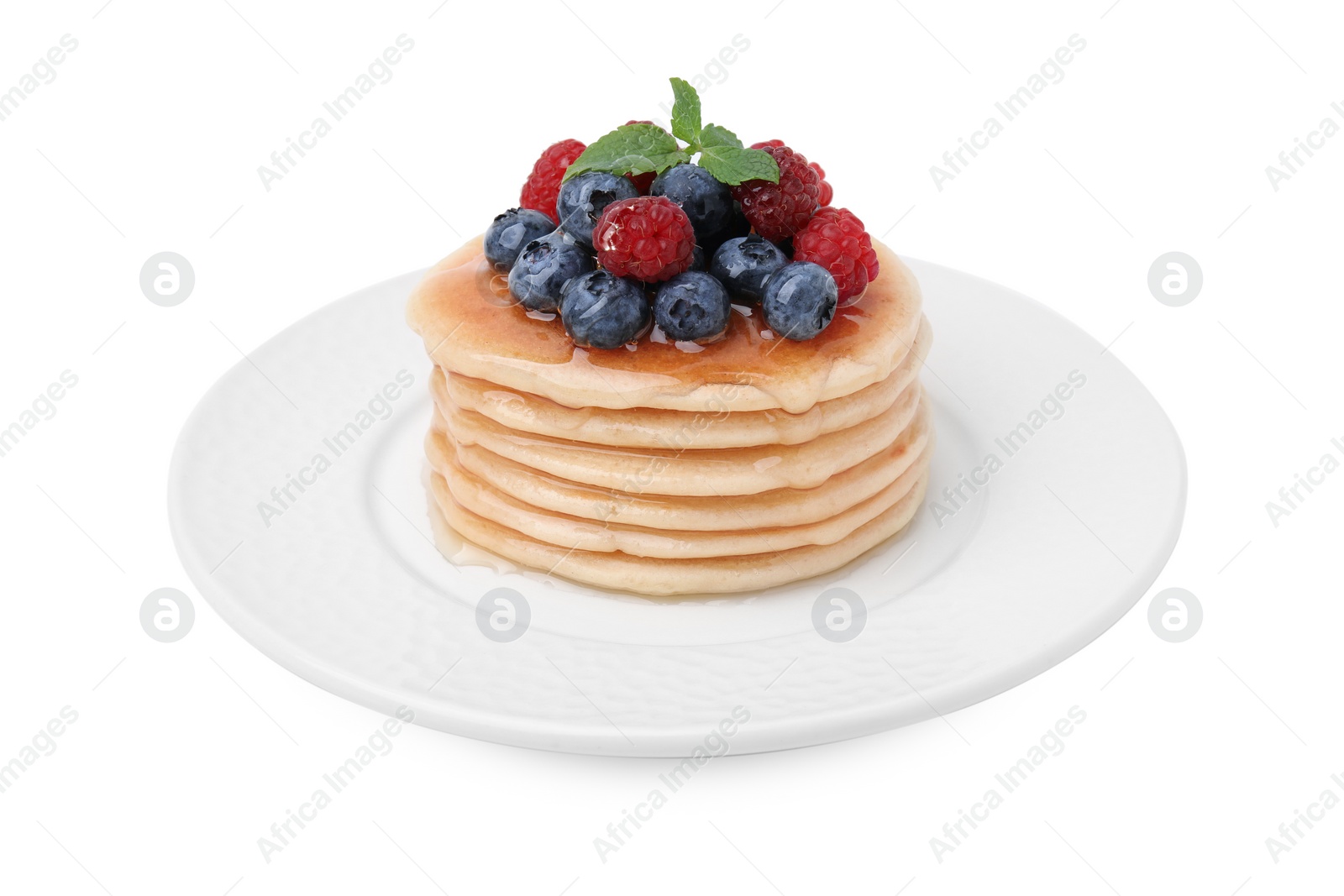 Photo of Delicious pancakes with berries, mint and honey isolated on white