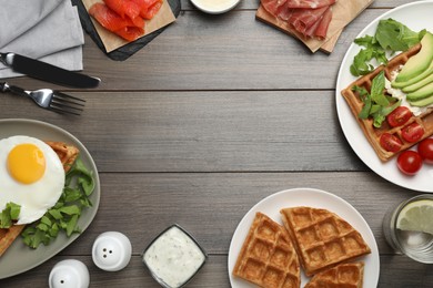Breakfast with fresh Belgian waffles and different toppings on wooden table, flat lay. Space for text