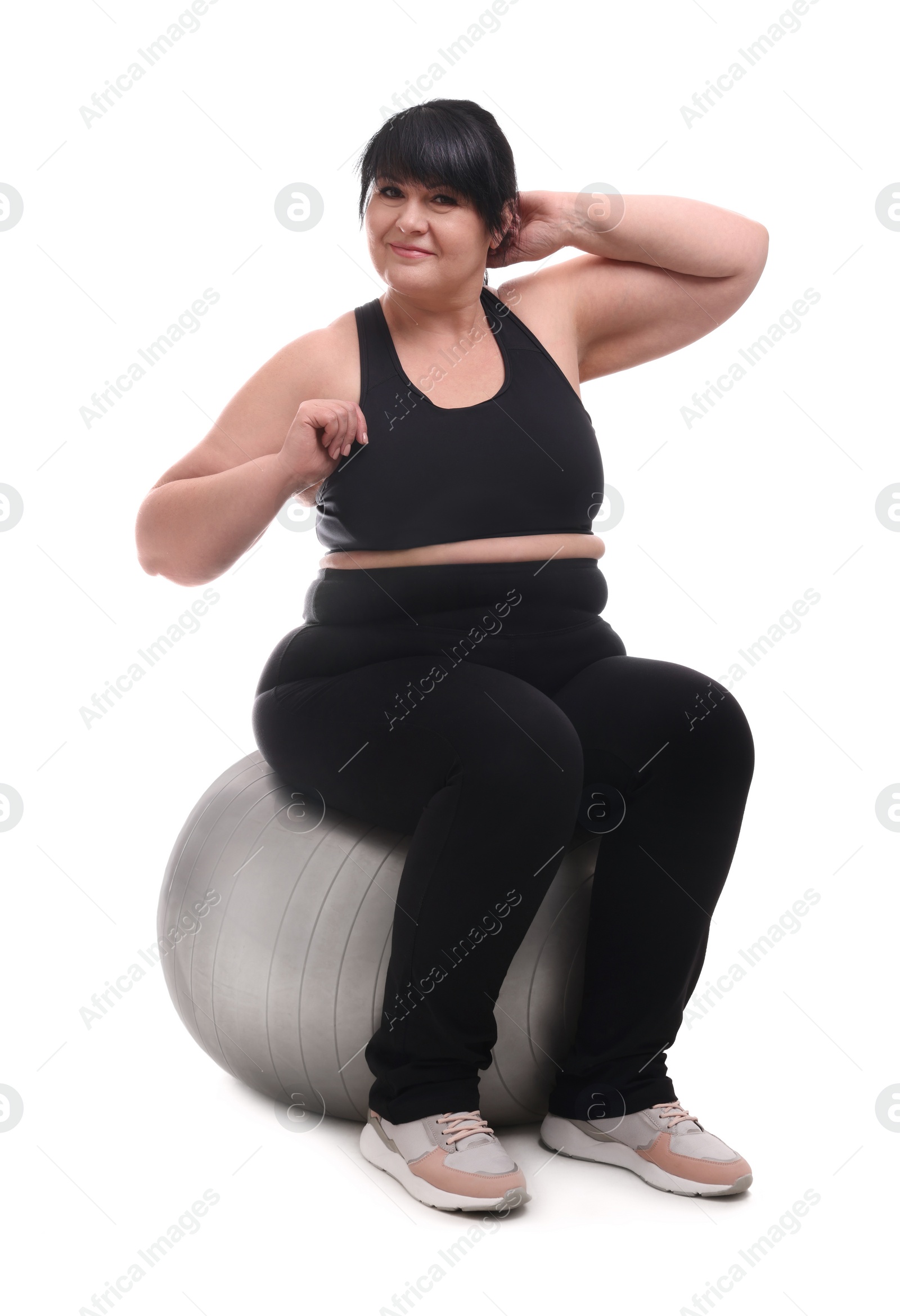 Photo of Happy overweight mature woman sitting on fitness ball against white background