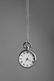 Photo of Stylish pendulum on grey background. Hypnotherapy session