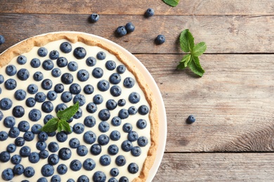 Flat lay composition with tasty blueberry cake and space for text on wooden table