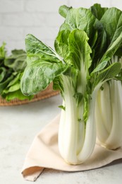 Photo of Fresh green pak choy cabbages on light table, closeup