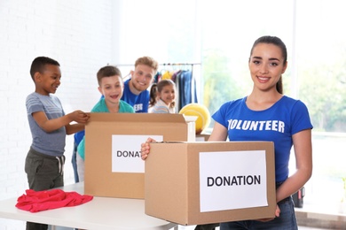 Volunteers with children sorting donation goods indoors