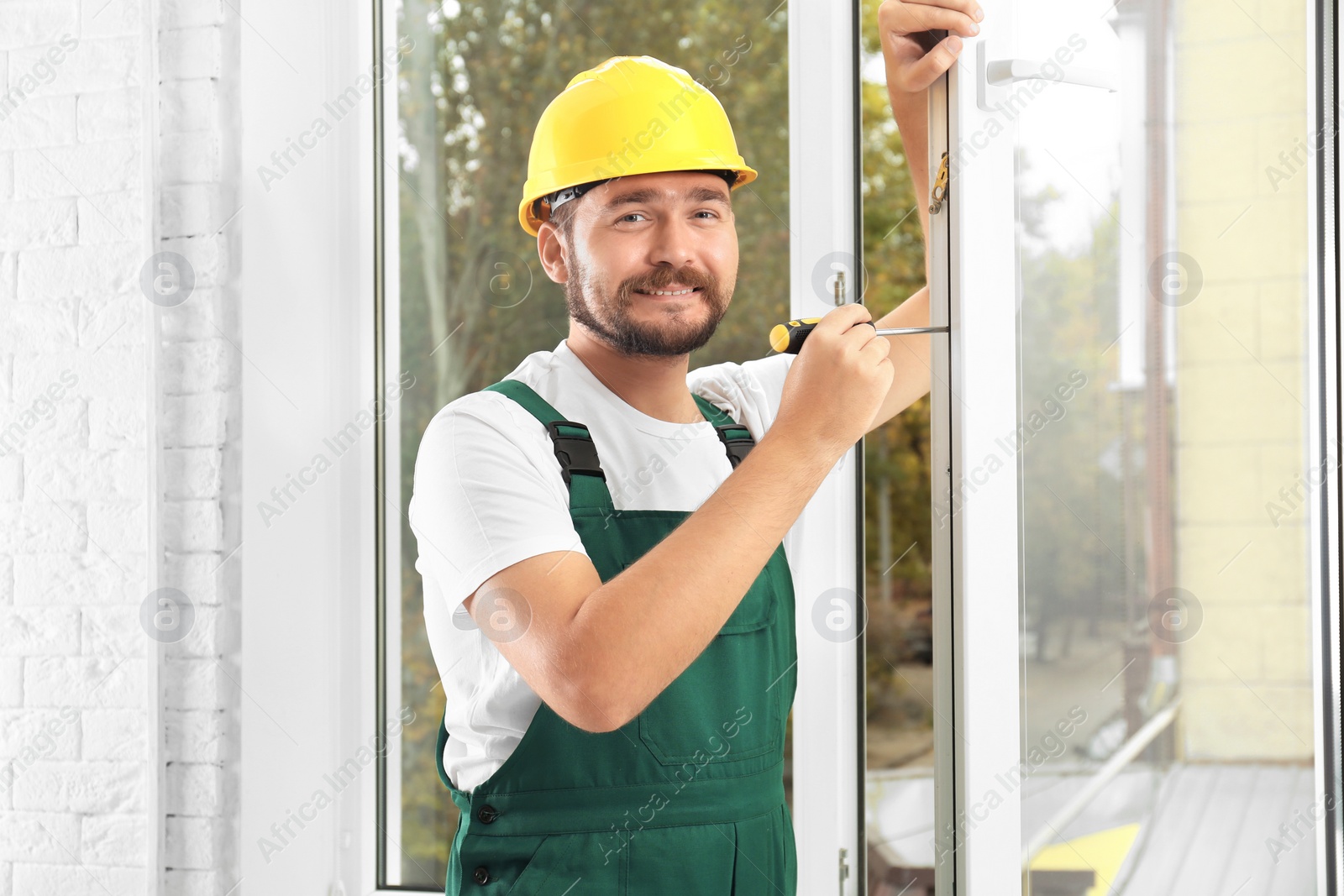 Photo of Construction worker installing new window in house