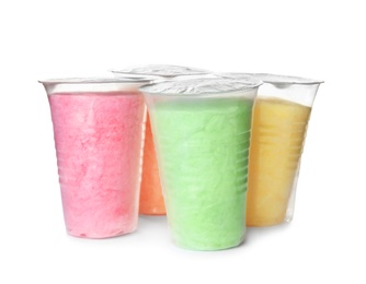 Yummy cotton candy in plastic cups on white background