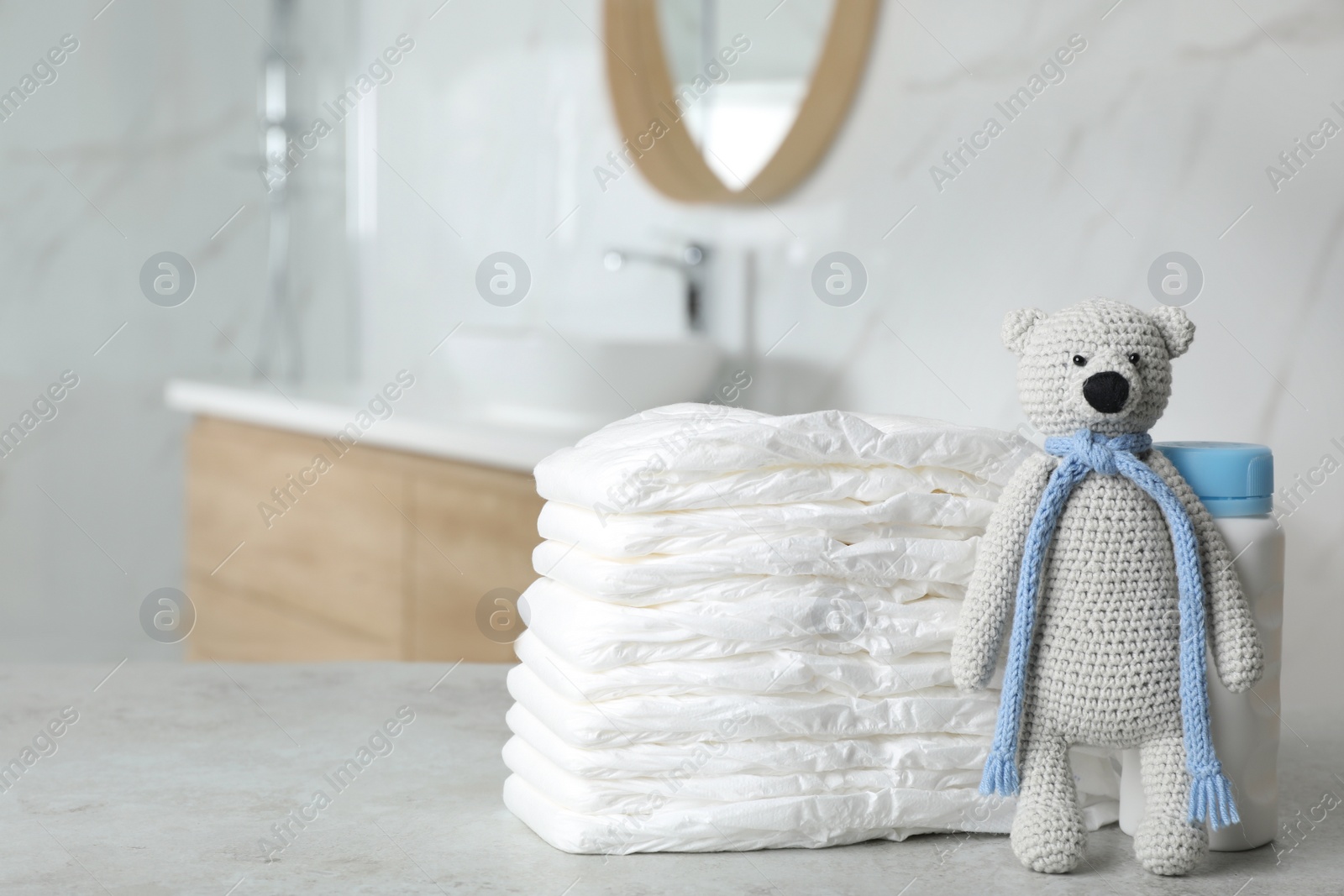 Photo of Stack of diapers and baby accessories on counter in bathroom. Space for text