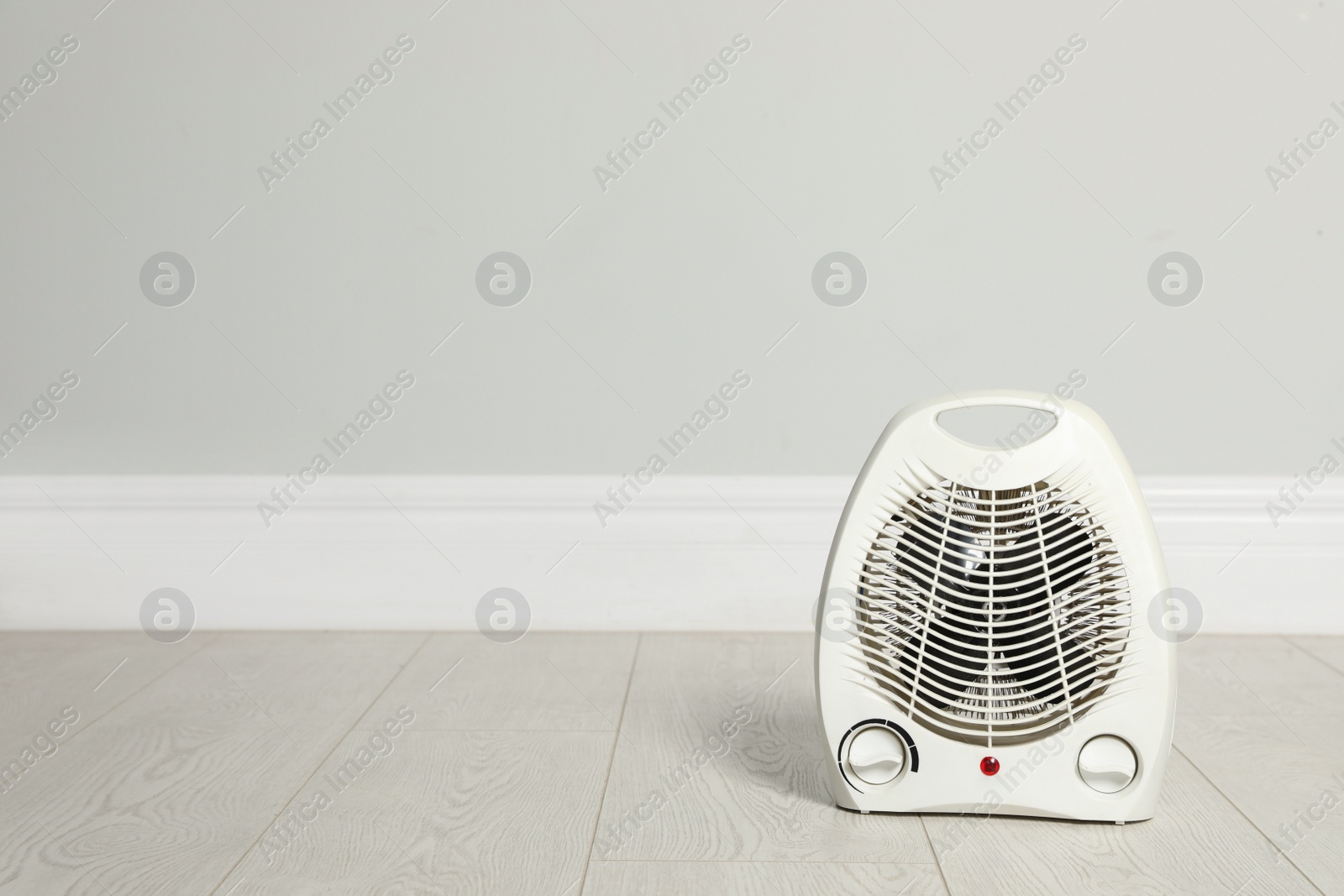 Photo of Modern electric fan heater on floor in room, space for text