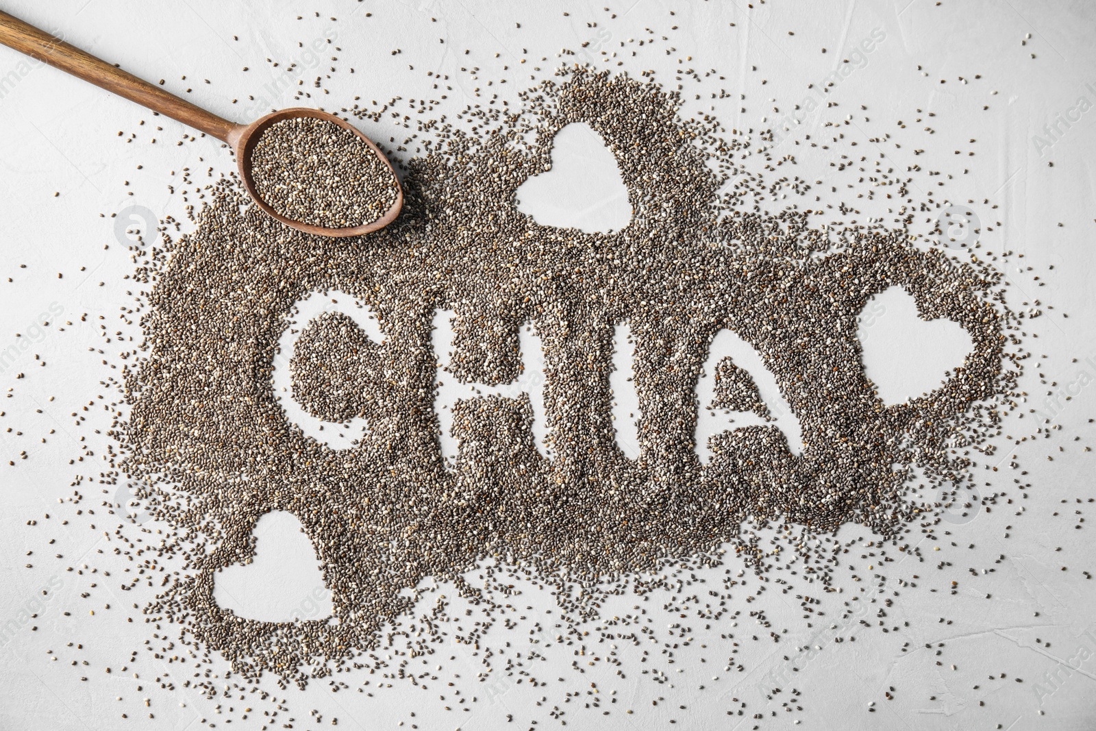 Photo of Spoon and word CHIA made of seeds on grey background, flat lay