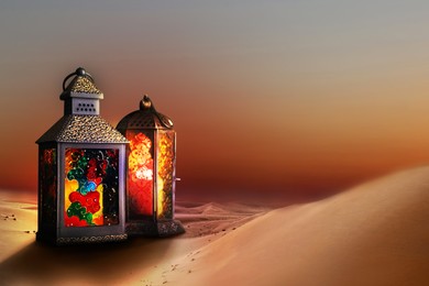 Beautiful Arabic lanterns on sand at sunset, space for text