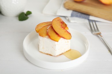 Photo of Delicious peach dessert on white wooden table
