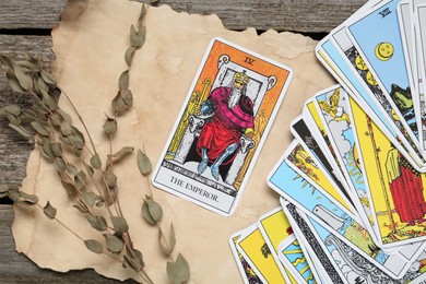 Photo of Flat lay composition with Emperor and other tarot cards on wooden table